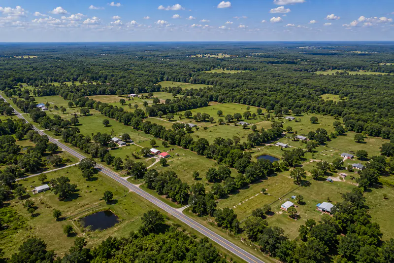 Rural Holmes County Florida acreage with pasture, fencing, pine trees, and road access