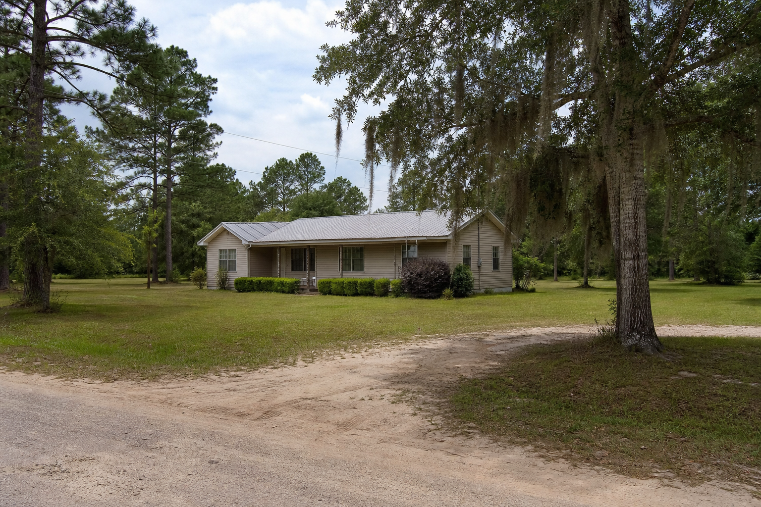 Modest rural North Florida Panhandle home on a roomy lot with pine trees, live oaks, Spanish moss, and sandy driveway access