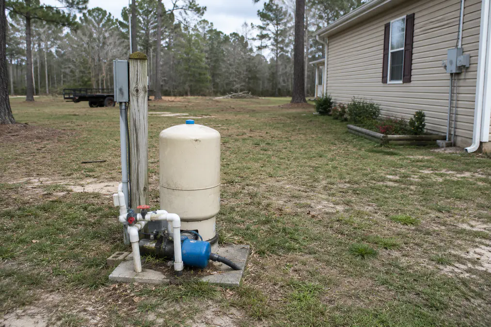 Private well equipment near a rural North Florida home and tree line